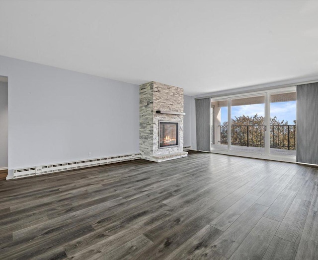 unfurnished living room with a stone fireplace, dark hardwood / wood-style flooring, and a baseboard heating unit