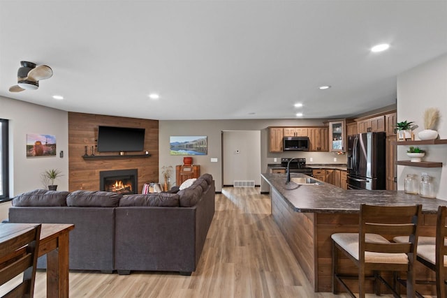 living room featuring sink, a fireplace, and light wood-type flooring