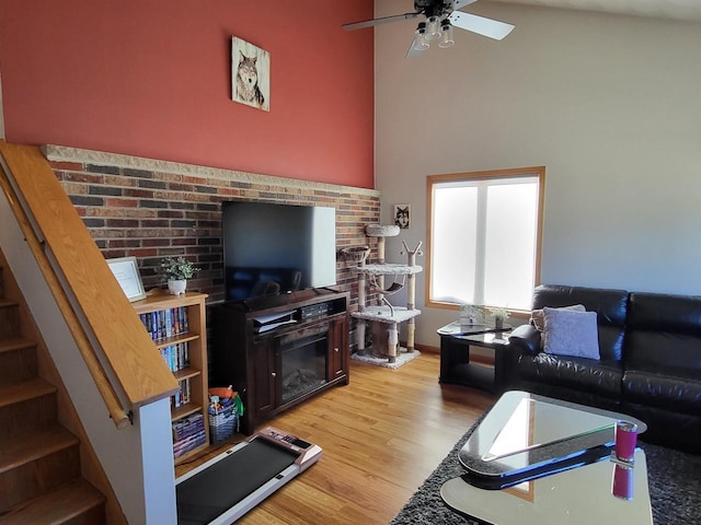 living room featuring ceiling fan, light hardwood / wood-style flooring, and high vaulted ceiling