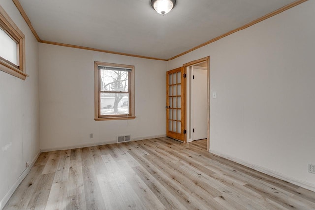 spare room with ornamental molding and light wood-type flooring