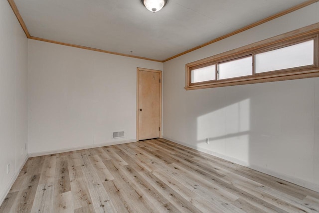 spare room featuring light hardwood / wood-style floors and crown molding