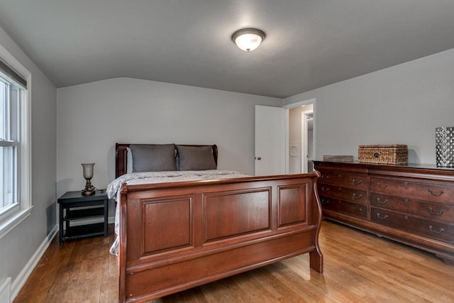 bedroom with hardwood / wood-style flooring and lofted ceiling