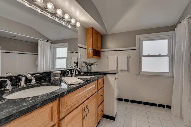 bathroom featuring tile walls, tile patterned flooring, vanity, and lofted ceiling