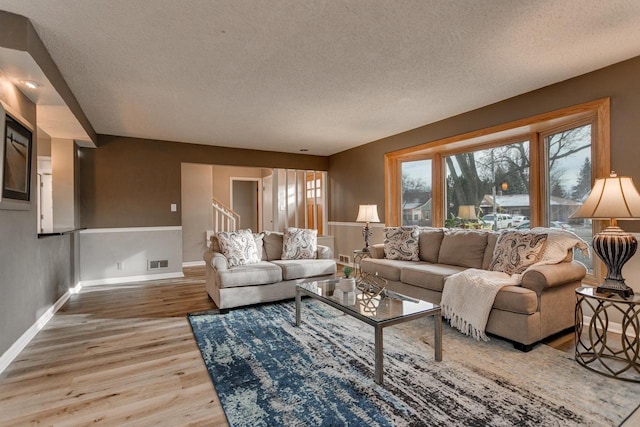 living room with light wood-type flooring and a textured ceiling