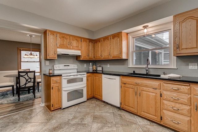 kitchen featuring pendant lighting, white appliances, a notable chandelier, and sink