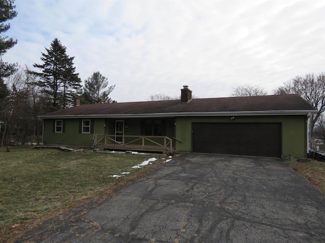 ranch-style home with covered porch, a front yard, and a garage