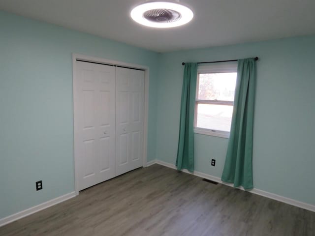 unfurnished bedroom featuring wood-type flooring and a closet