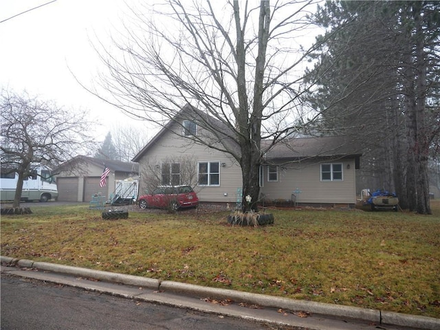 view of front facade with an outdoor structure, a front yard, and a garage