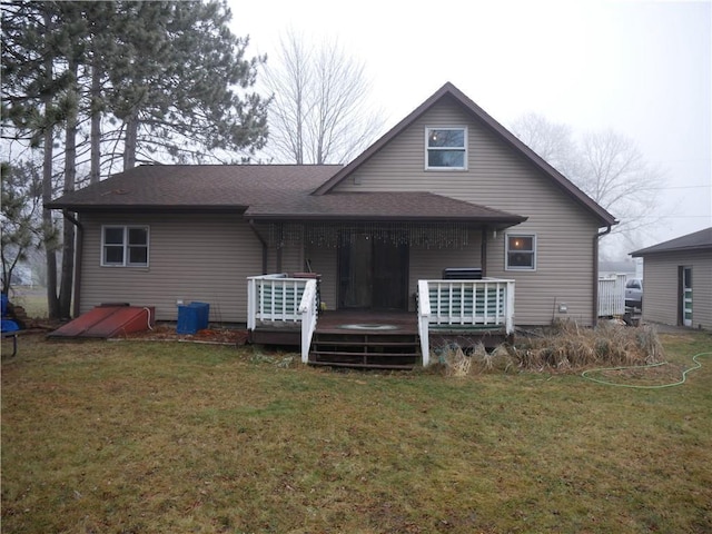 back of house featuring a lawn and a wooden deck