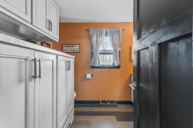 interior space featuring white cabinetry and dark wood-type flooring