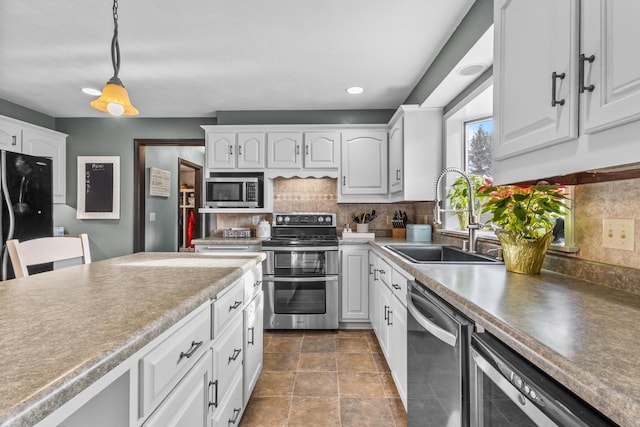 kitchen featuring stainless steel appliances, white cabinetry, and sink