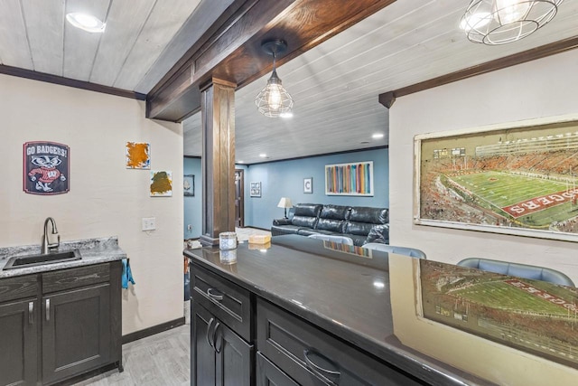 kitchen featuring ornamental molding, light hardwood / wood-style flooring, wooden ceiling, and sink