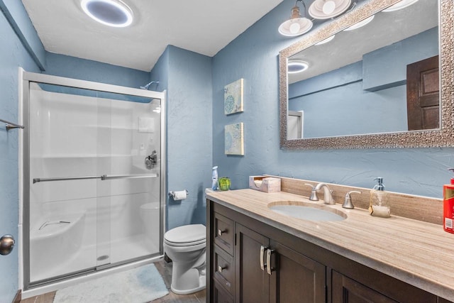 bathroom with vanity, an enclosed shower, and toilet