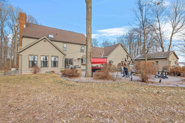 back of property featuring a patio area and a lawn