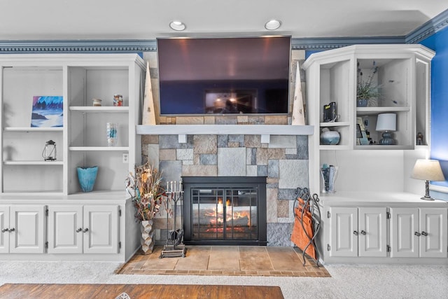 living room with built in shelves and a stone fireplace