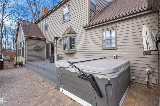 exterior space with a patio area, an outdoor kitchen, and a hot tub