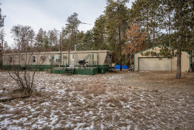 manufactured / mobile home with a wooden deck, an outbuilding, and a garage