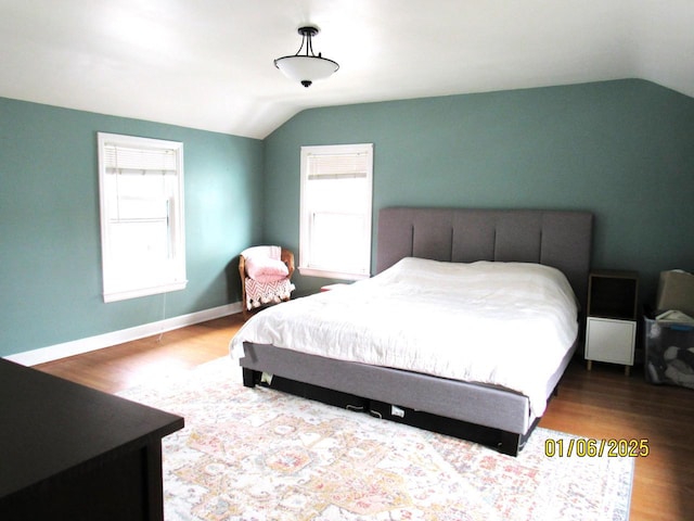 bedroom with hardwood / wood-style floors and lofted ceiling