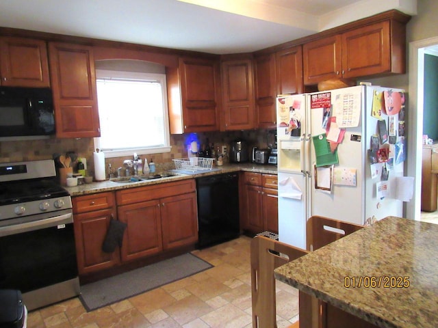 kitchen featuring black appliances, backsplash, light stone counters, and sink