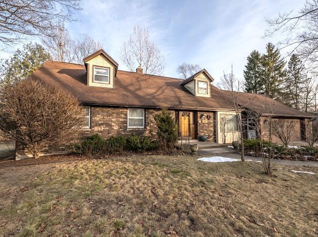 cape cod-style house with a front lawn