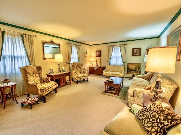 carpeted living room featuring crown molding