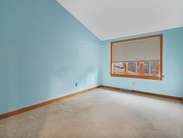 carpeted spare room with lofted ceiling