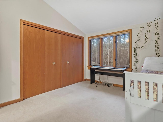 carpeted bedroom featuring lofted ceiling and a closet