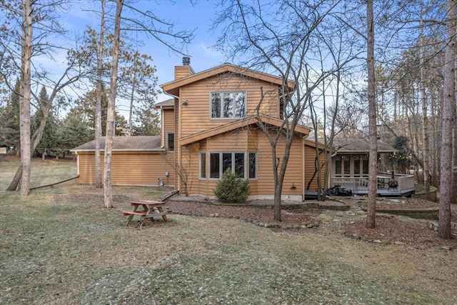 rear view of property with a yard and a wooden deck