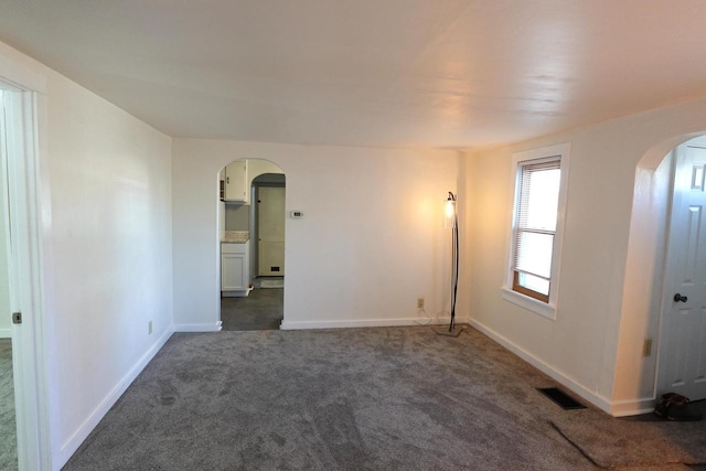 unfurnished room with dark colored carpet