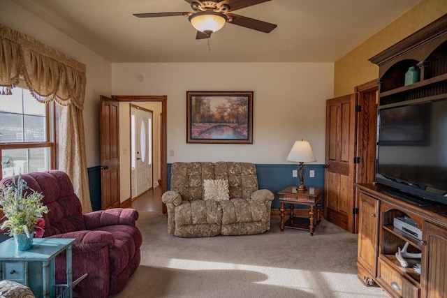 carpeted living room with ceiling fan