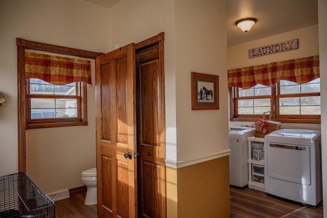 clothes washing area with washing machine and dryer and dark hardwood / wood-style floors