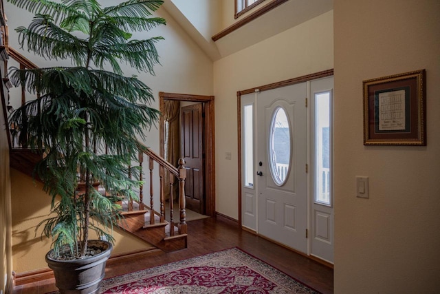 foyer with hardwood / wood-style floors and high vaulted ceiling