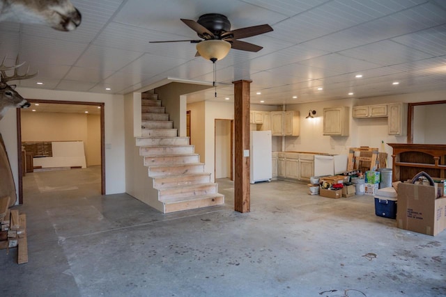 basement featuring ceiling fan and white refrigerator