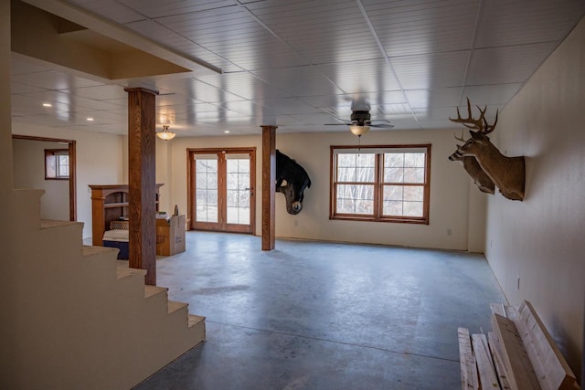 interior space featuring ceiling fan, concrete flooring, and ornate columns