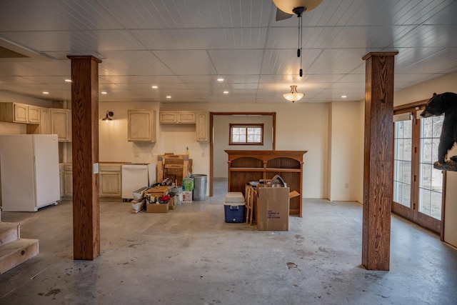 basement with a wealth of natural light, french doors, and white refrigerator