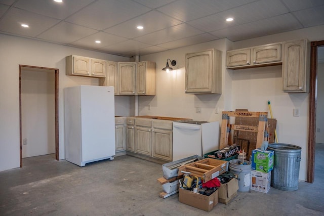 kitchen with light brown cabinetry, a drop ceiling, and white refrigerator