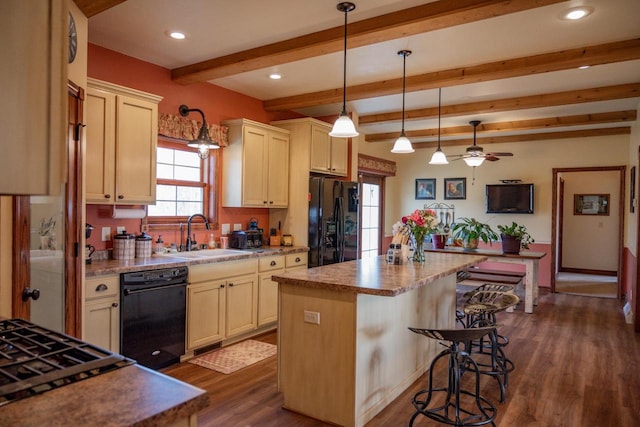 kitchen featuring dark wood-type flooring, sink, black appliances, beamed ceiling, and a center island