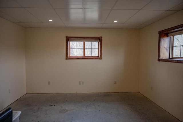 empty room with a wealth of natural light and a drop ceiling