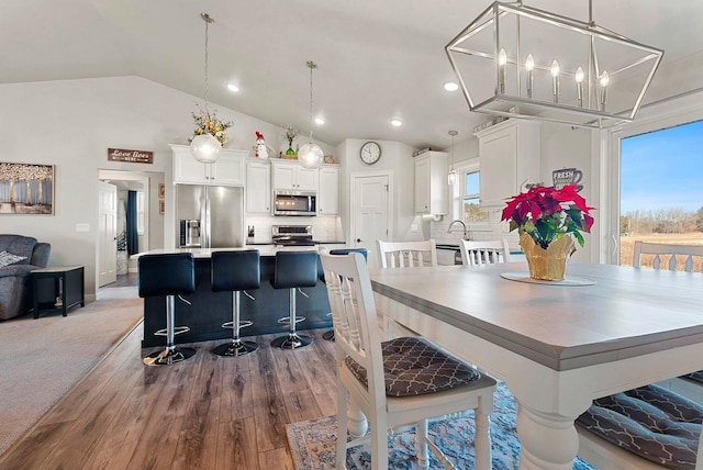 dining room featuring light hardwood / wood-style floors and vaulted ceiling