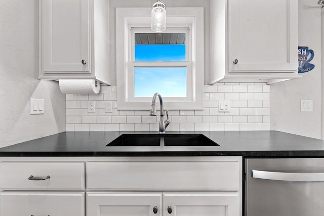 kitchen with backsplash, sink, pendant lighting, dishwasher, and white cabinetry