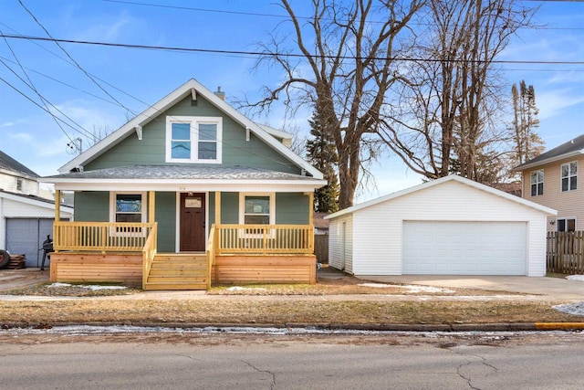 bungalow-style home with a porch, a garage, and an outbuilding