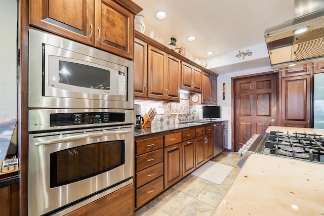 kitchen with sink, decorative backsplash, light tile patterned floors, exhaust hood, and appliances with stainless steel finishes