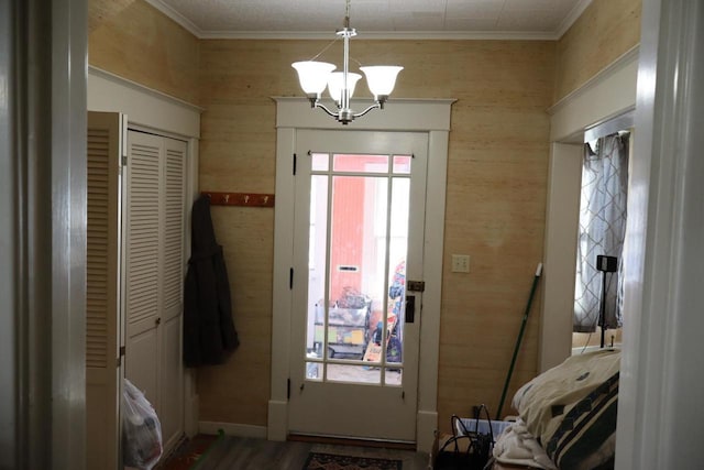 entryway featuring wooden walls, crown molding, and a notable chandelier