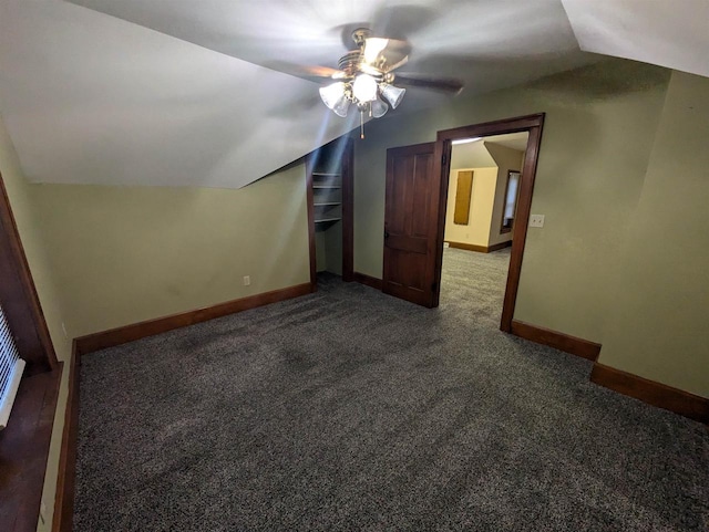 additional living space featuring ceiling fan, dark carpet, and lofted ceiling