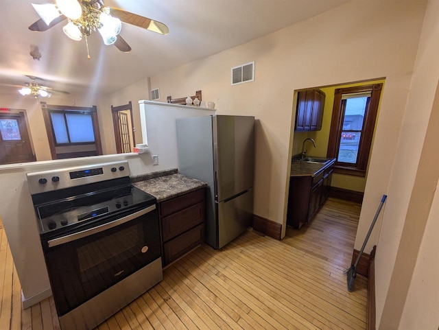 kitchen with dark brown cabinets, stainless steel appliances, ceiling fan, sink, and light hardwood / wood-style flooring