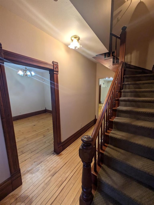 stairs featuring a notable chandelier and hardwood / wood-style flooring