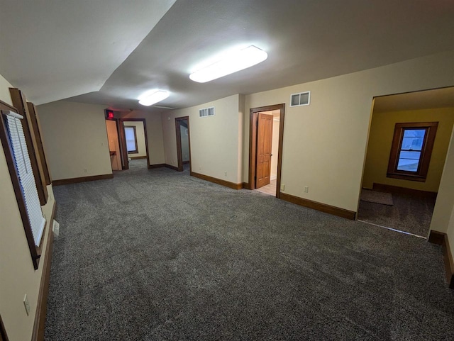 carpeted spare room featuring lofted ceiling