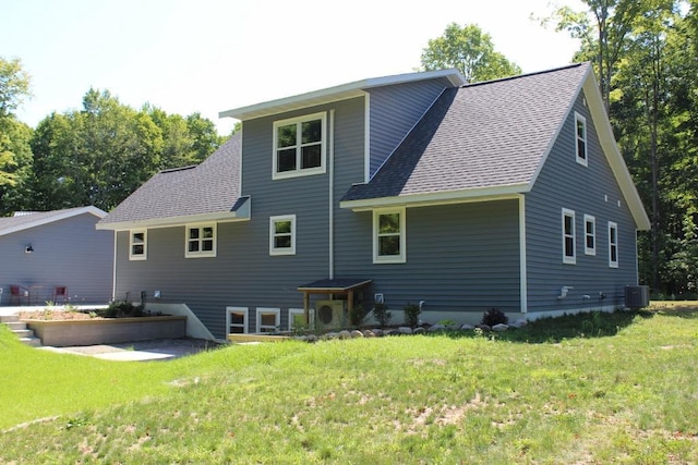 back of property featuring a lawn and central AC