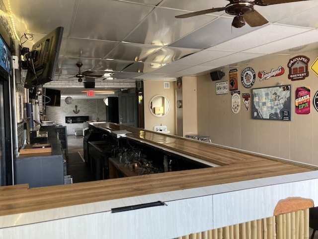 kitchen featuring a drop ceiling and wooden counters