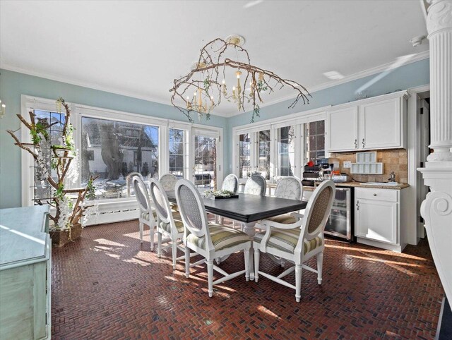 dining space with a healthy amount of sunlight, crown molding, and a chandelier